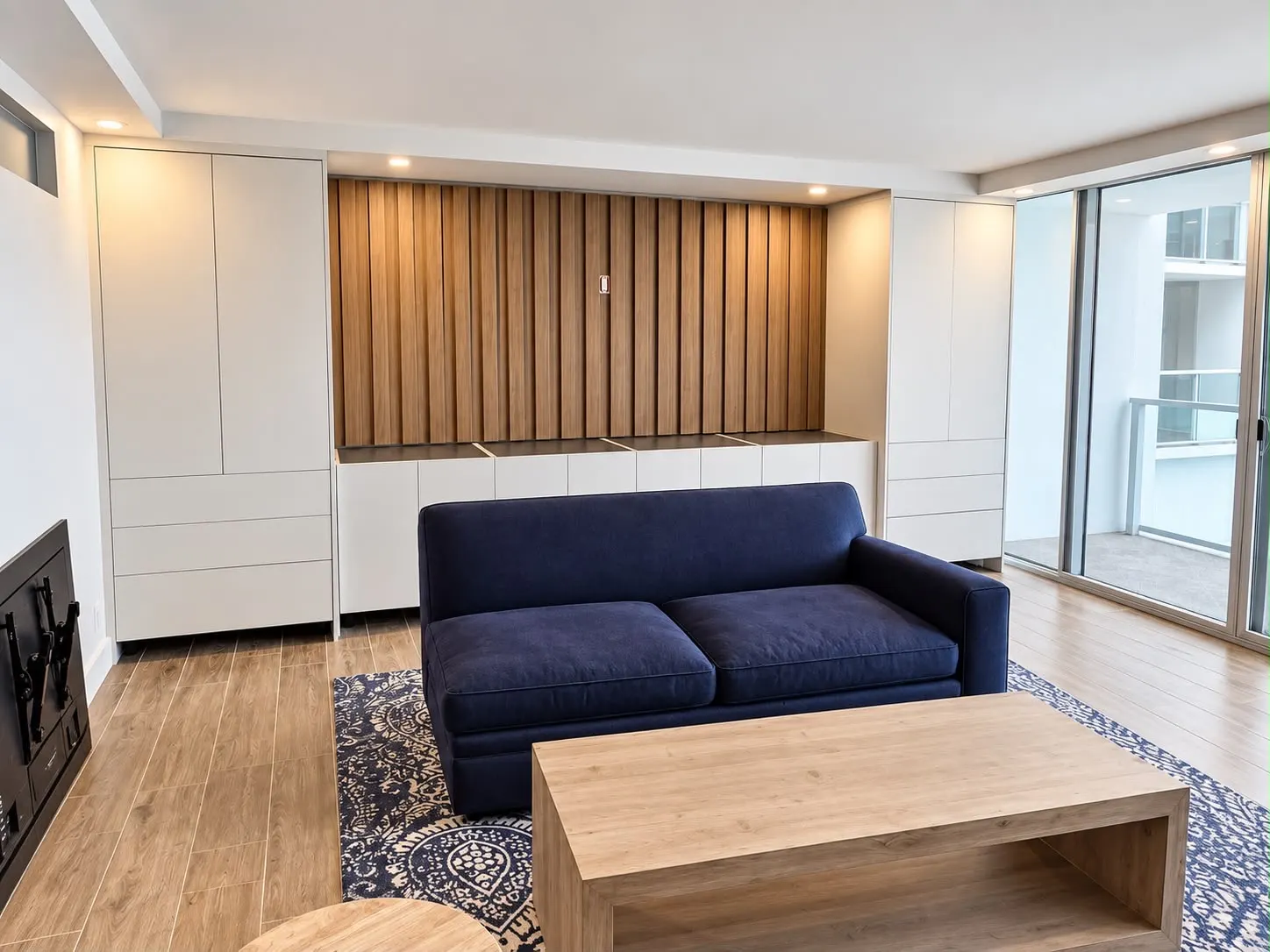 Living room wall with white built-in cabinets flanking a fluted oak panel and a low console